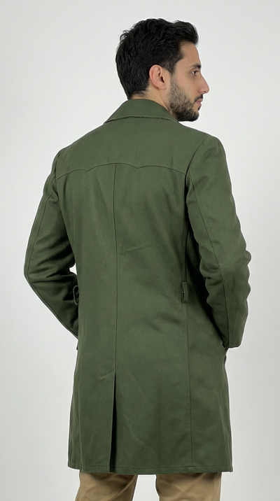 Man wearing a green coat and beige pants on a white background