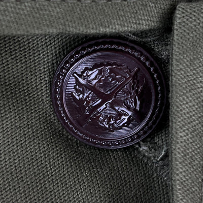 Close-up of a decorative button on a green fabric background