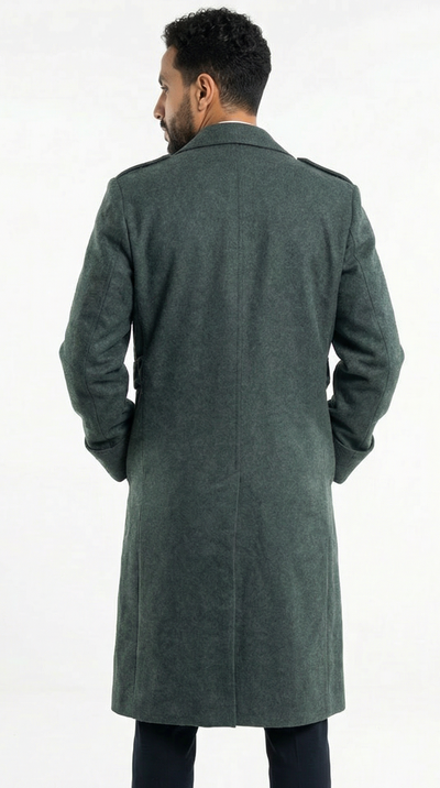 Man wearing a green overcoat standing against a white background