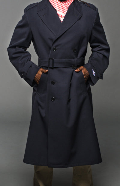 Military style navy blue gabardine trench coat with belt, double-breasted, epaulettes, and slanted pockets.