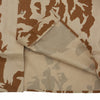 Folded fabric with a camouflage pattern in brown and beige tones.