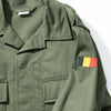 Green military jacket with a flag patch on the sleeve against a white background