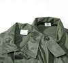 Green belgian field shirt with a collar and button detail on a white background