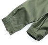 Close-up of green field shirt sleeves with rolled-up cuffs on a white background