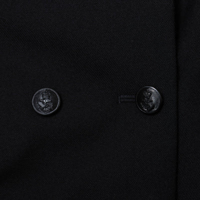 Close-up of a black coat with two buttons on a dark background