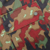 Close-up of camouflage fabric with buttons and stitching details