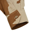 Close-up of a camouflage-patterned sleeve with a button on a white background