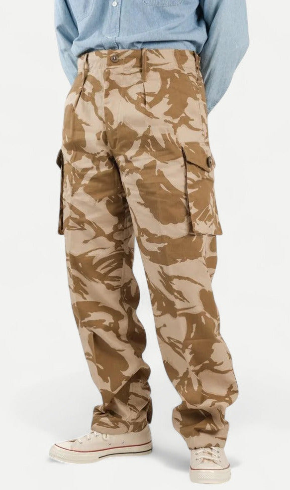 Camouflage pants worn by a person on a white background