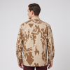 A man modeling a camouflage jacket from the back in a top panel, with two side-profile front views below on a light gray studio background. The jacket has a tan and brown camouflage pattern and is worn over a white T-shirt and dark burgundy pants.