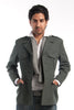 Man wearing a gray jacket, white shirt, and blue jeans on a white background