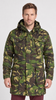 A man wearing a hooded camouflage parka jacket with multiple front pockets, photographed against a plain light gray studio background.