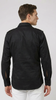 Man wearing a black jacket and white pants on a white background