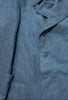 Close-up of a gray coat with buttons on a wooden surface