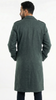 Man wearing a green overcoat standing against a white background